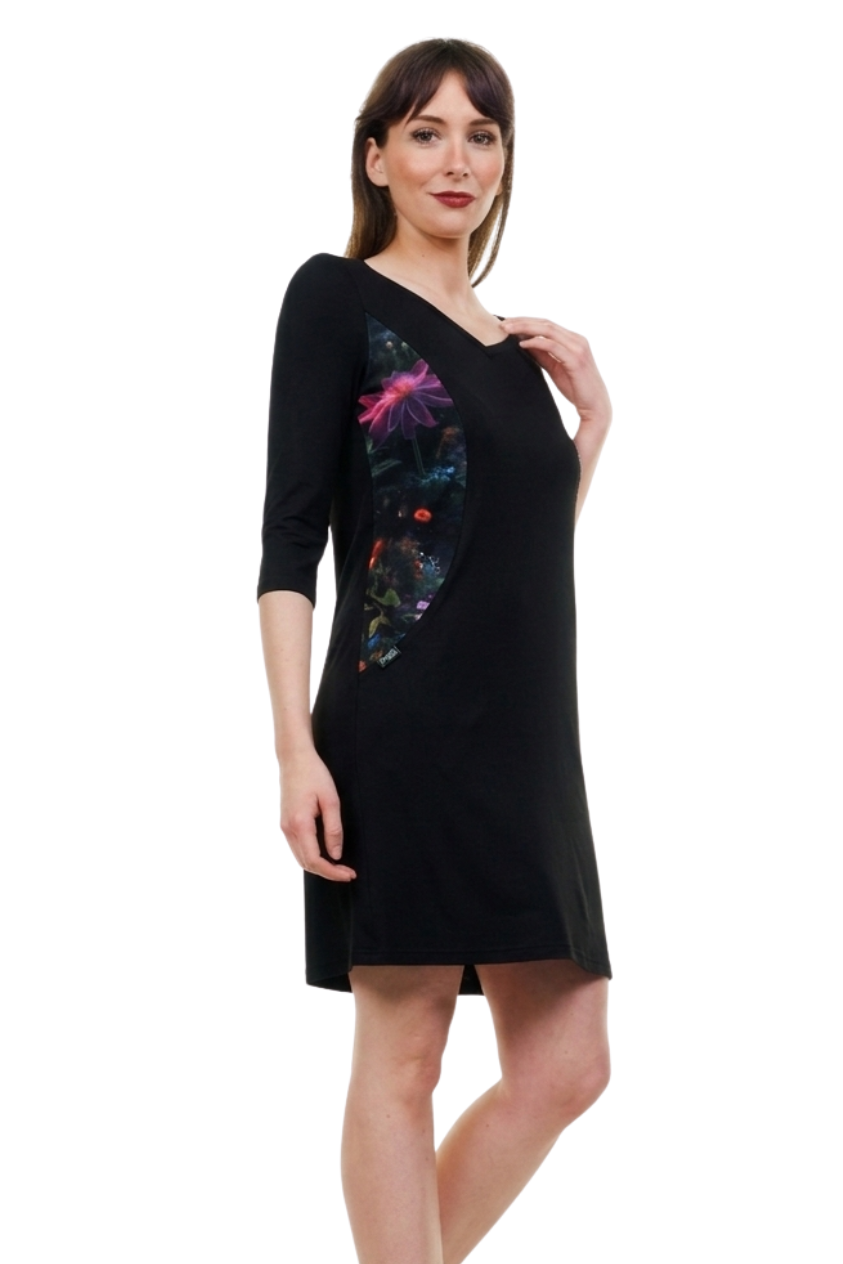 Modell trägt das figurbetonte Flora Fantasia Designerkleid aus Berlin vor einem mystischen, floralen Hintergrund