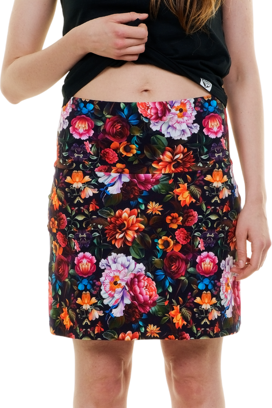 Vorderansicht eines kurzen Sommerrocks Modell "Nachtwiese" mit intensivem, floralem Muster auf schwarzem Grund (Nachtgarten-Optik), getragen von einer Frau, handgefertigt in Berlin