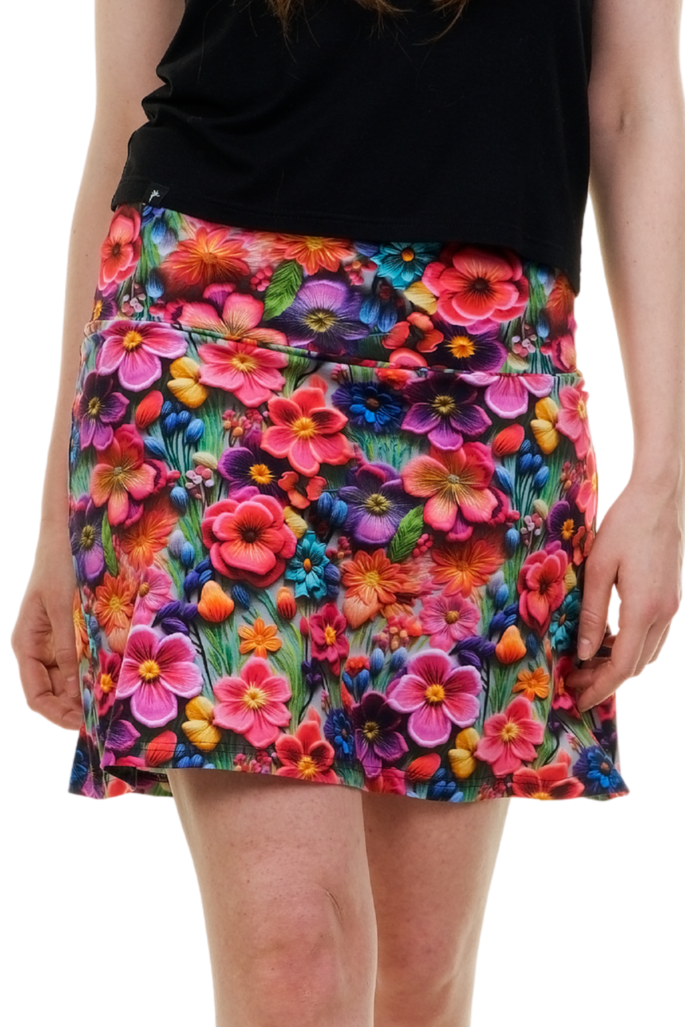 Vorderansicht eines kurzen Sommerrocks Modell "Blossom Wonderland" mit intensivem, farbenfrohem Blumenmuster (pink, lila, orange) auf einer Frau, handgefertigt in Berlin.