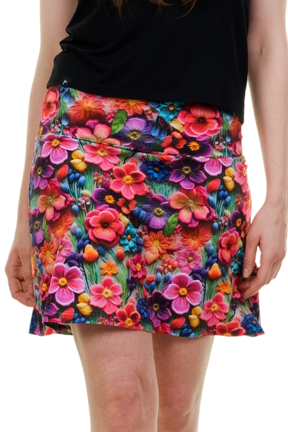 Vorderansicht eines kurzen Sommerrocks Modell "Blossom Wonderland" mit intensivem, farbenfrohem Blumenmuster (pink, lila, orange) auf einer Frau, handgefertigt in Berlin.