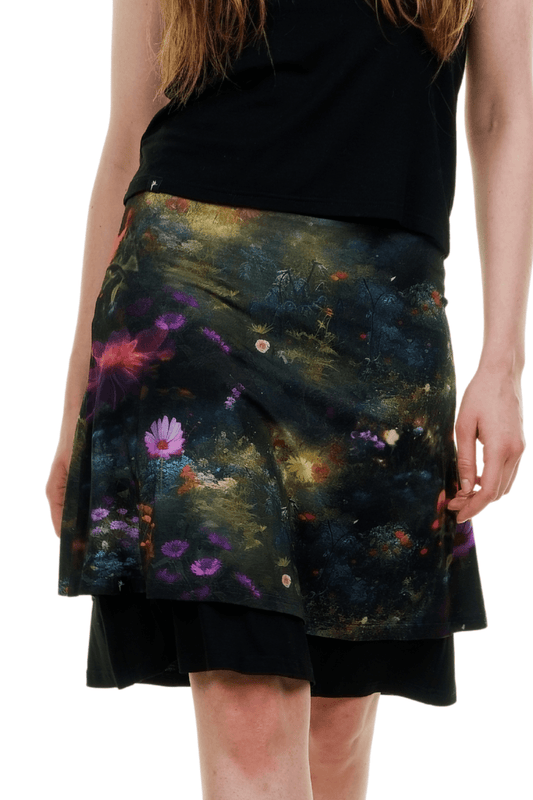 Frau trägt Flora Fantasia Rock mit bunten Blumen auf dunklem Grund, zweilagiger Schnitt, Wald-Hintergrund